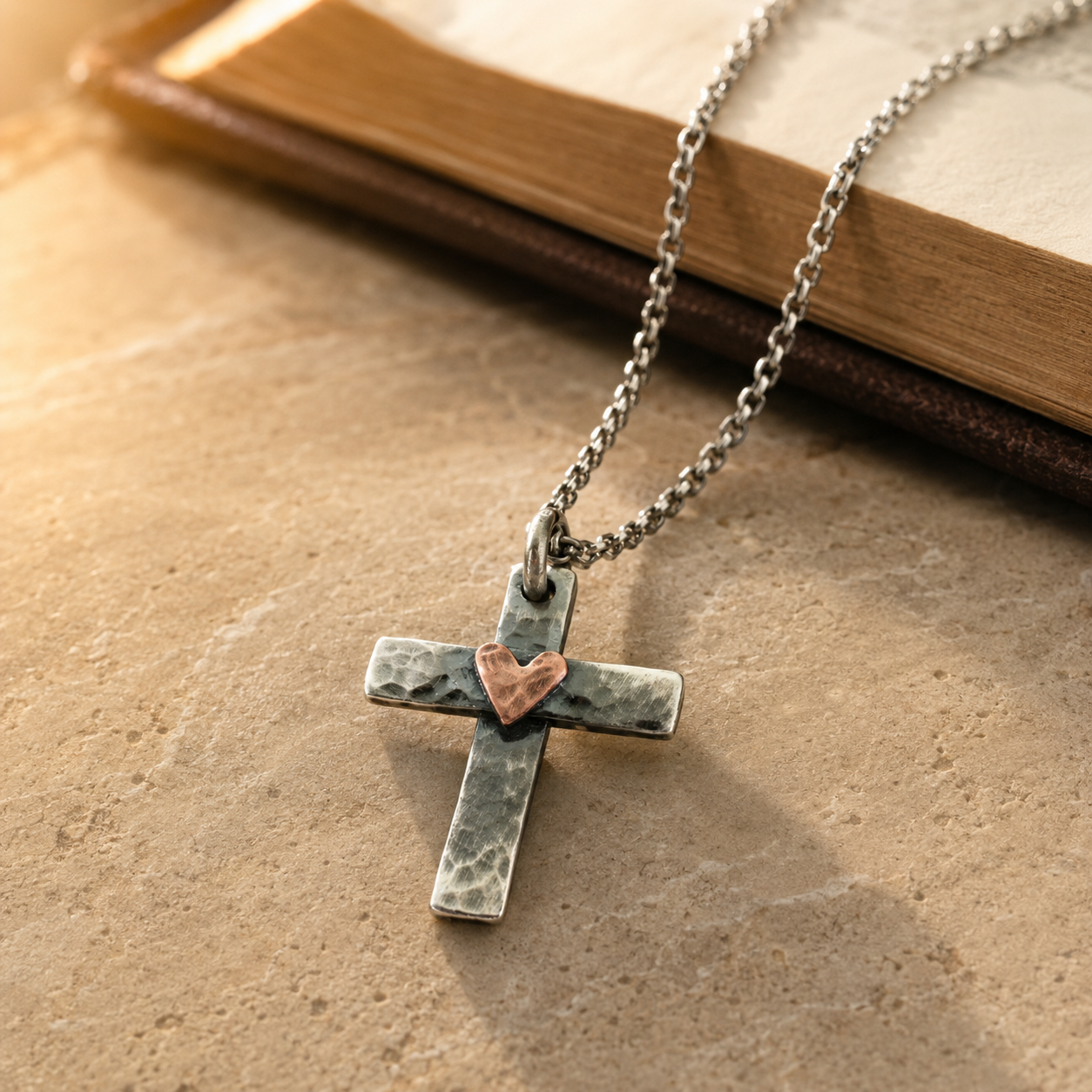 Colgante Cruz con Corazón Forjado a Mano — escena editorial con Biblia