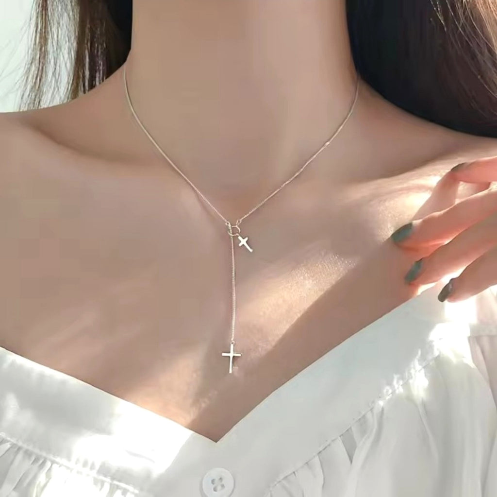 Collar cristiano plateado de doble cruz usado por modelo