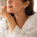 Mujer usando Pulsera Loida y aros de cruz del Pack Legado de Fe