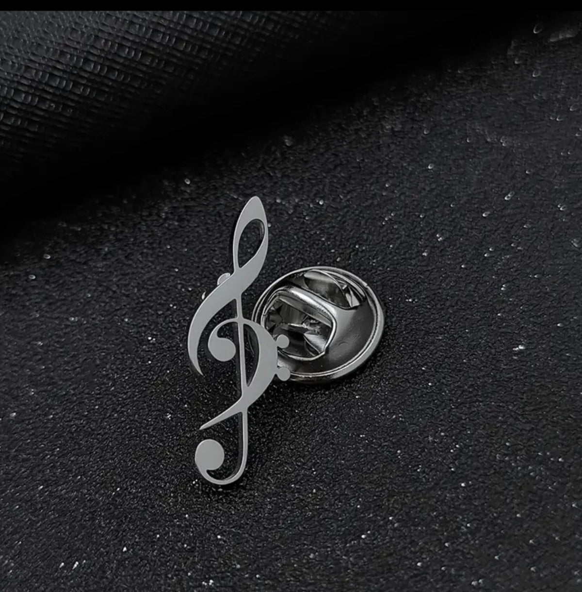 Detalle del broche posterior del pin clave de sol